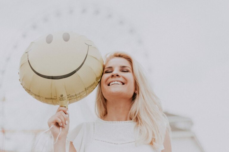 A close up of a person with a smiley face balloon