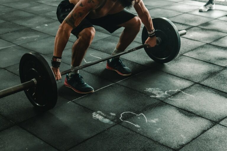 Man holding Barbell weights on the ground