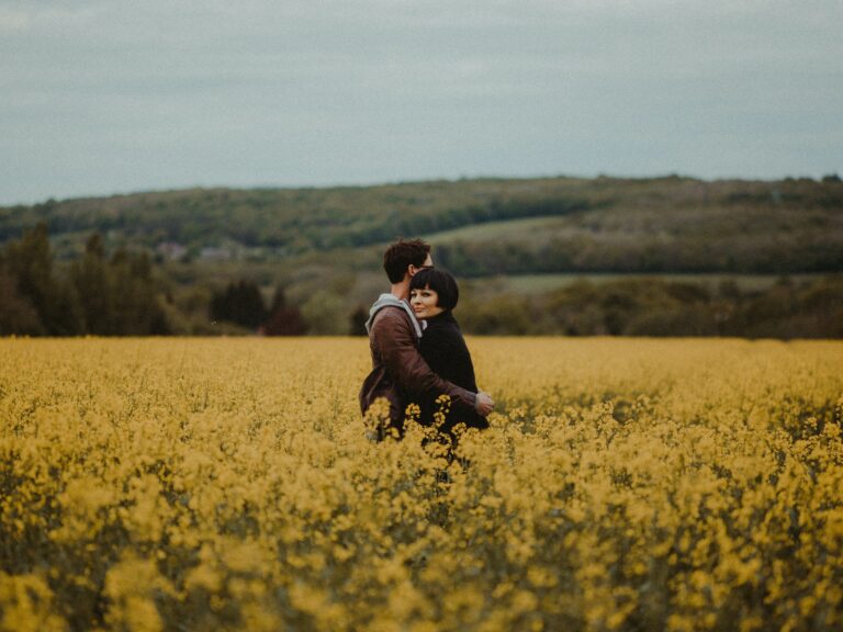 Male and female in a field of flowers hugging