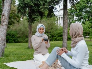 Two women having a picnic in a park smiling
